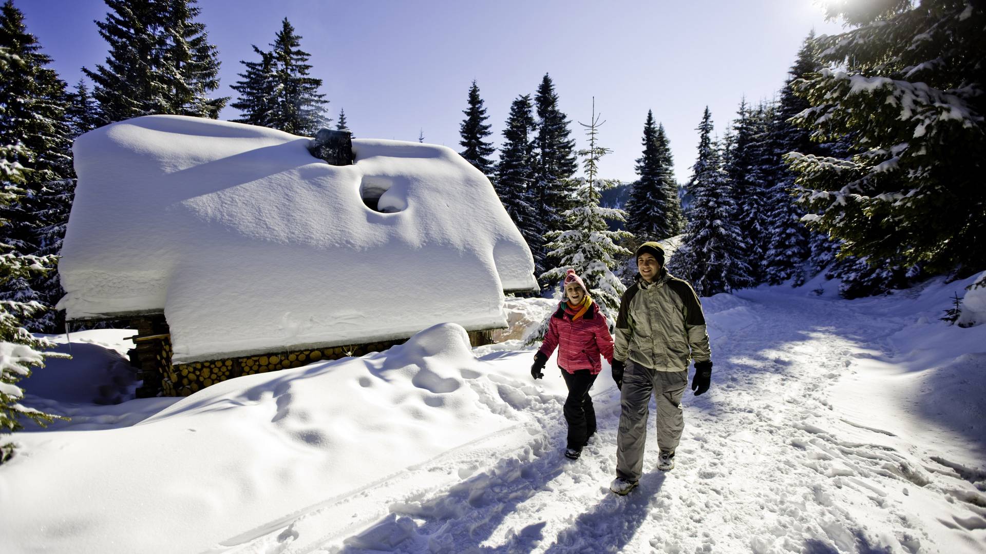 Winterwandern vor der tiefverschneiten Hütte